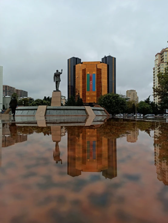 a statue of a person standing near a lake