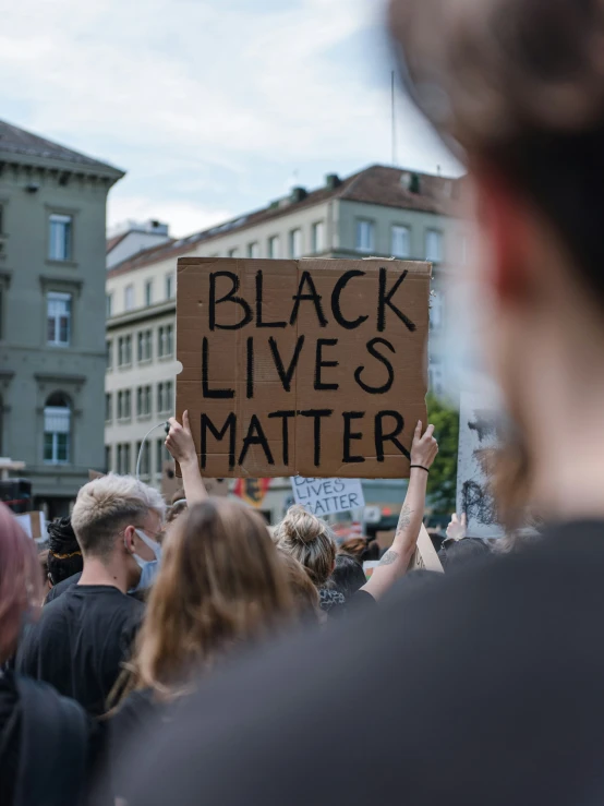 many people are standing outside and holding signs