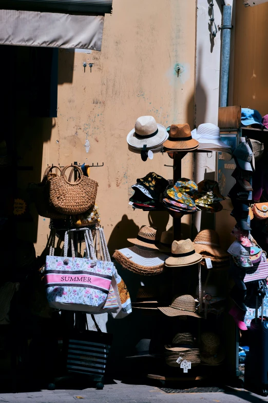 a pile of hats on display near a building