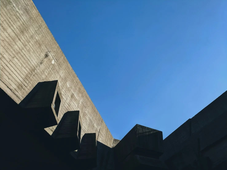 the blue sky is so far from the top of the brick wall