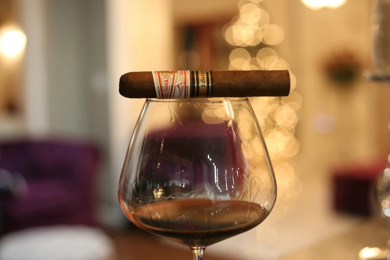 a cigar in a wine glass with a cork