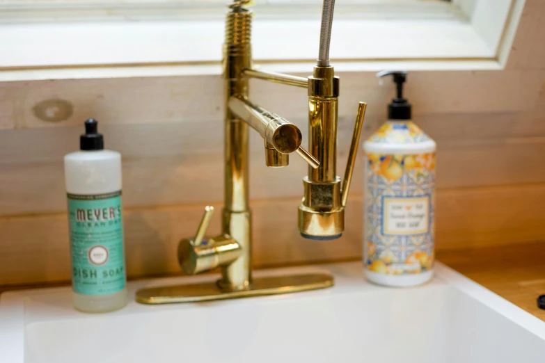 a gold faucet over a sink in a bathroom