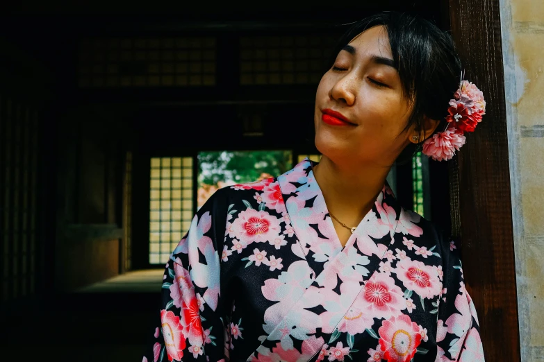 a woman with flowers in her hair wearing an oriental outfit