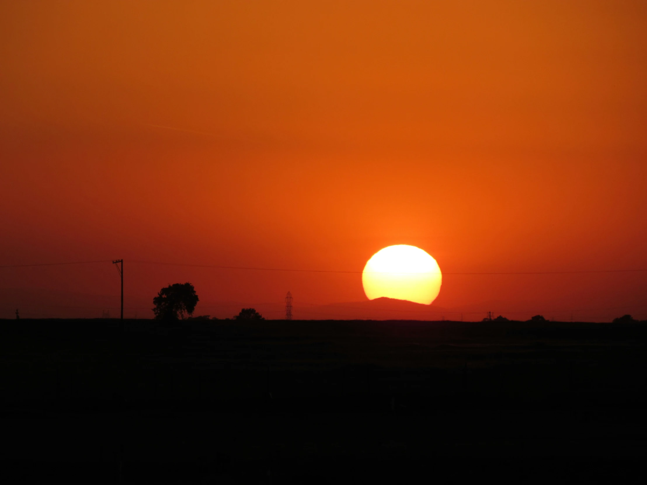 a large orange ball of sun in the sky