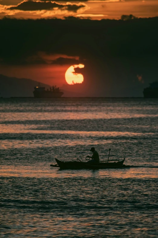 the sunset casts an orange light on the water