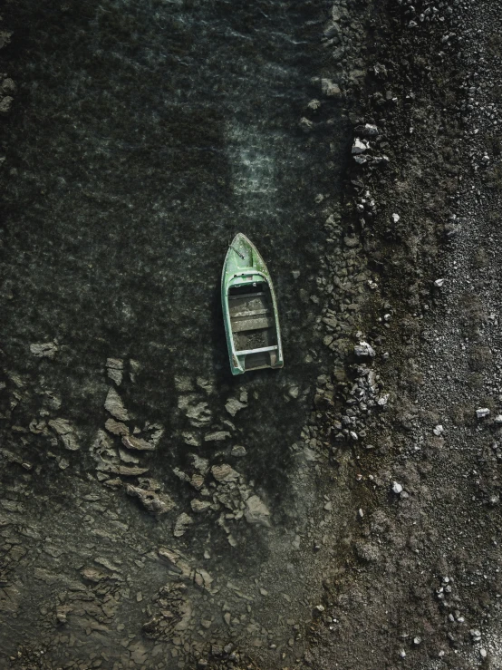 a boat floating on top of a lake with rocks