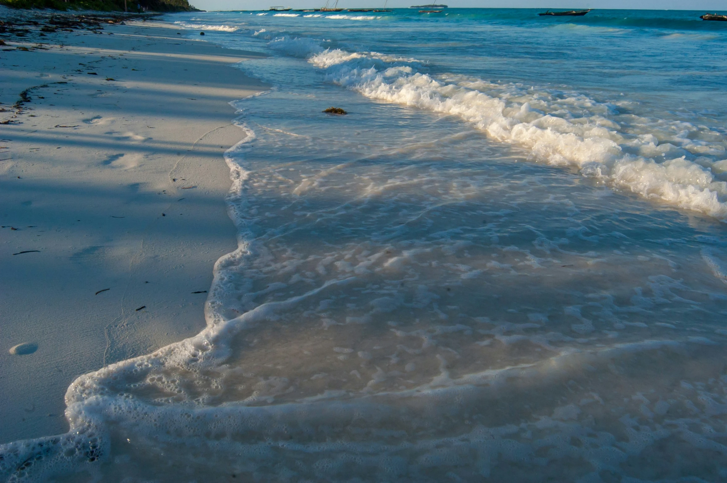 waves are coming on the beach during low tide