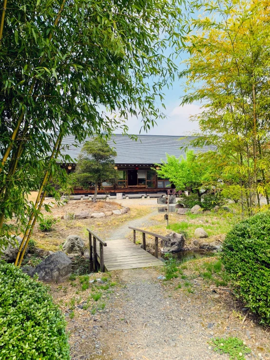 a wooden walkway crosses the small gravel path near an old building