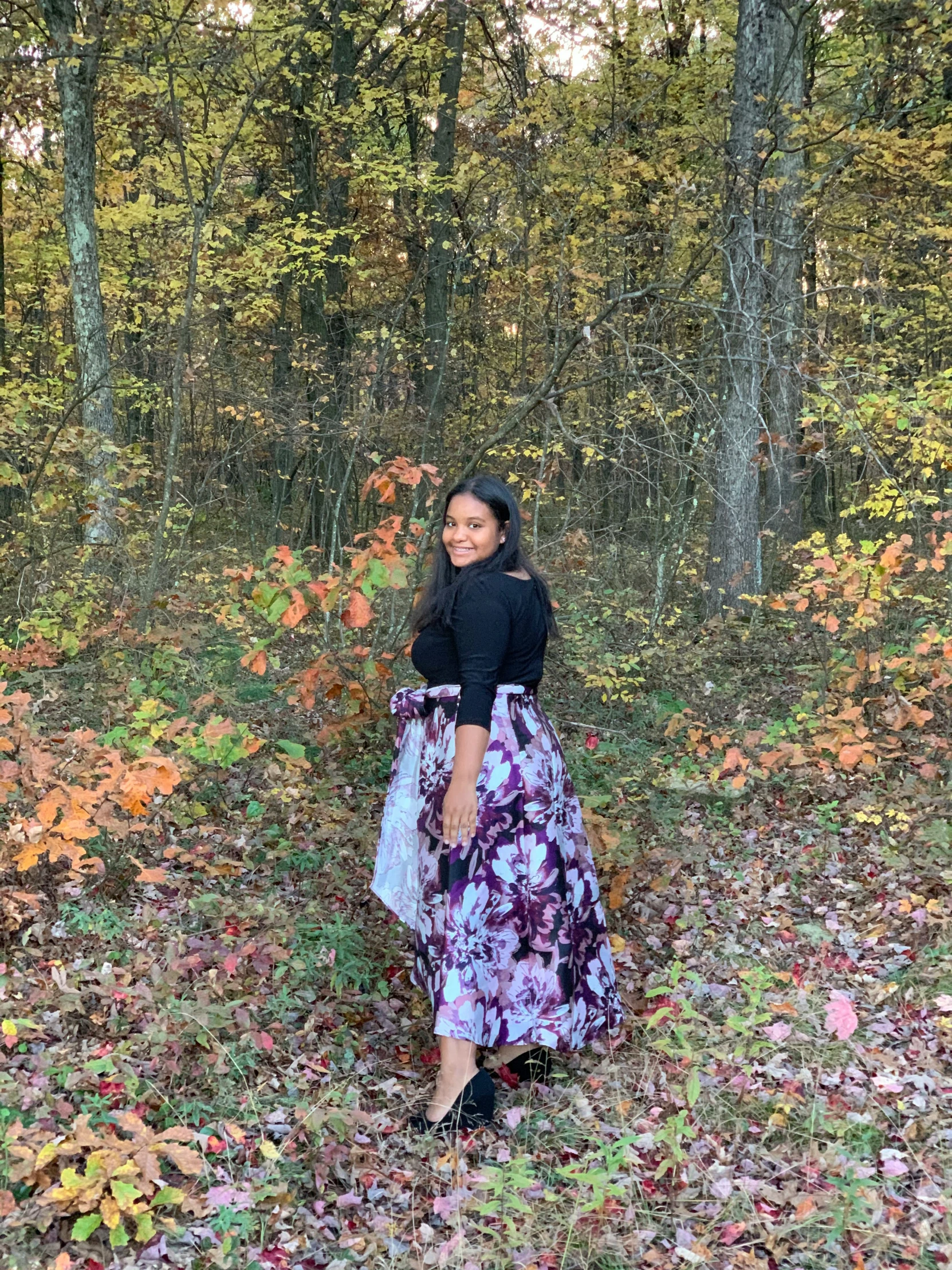 a woman posing in the leaves with a dress