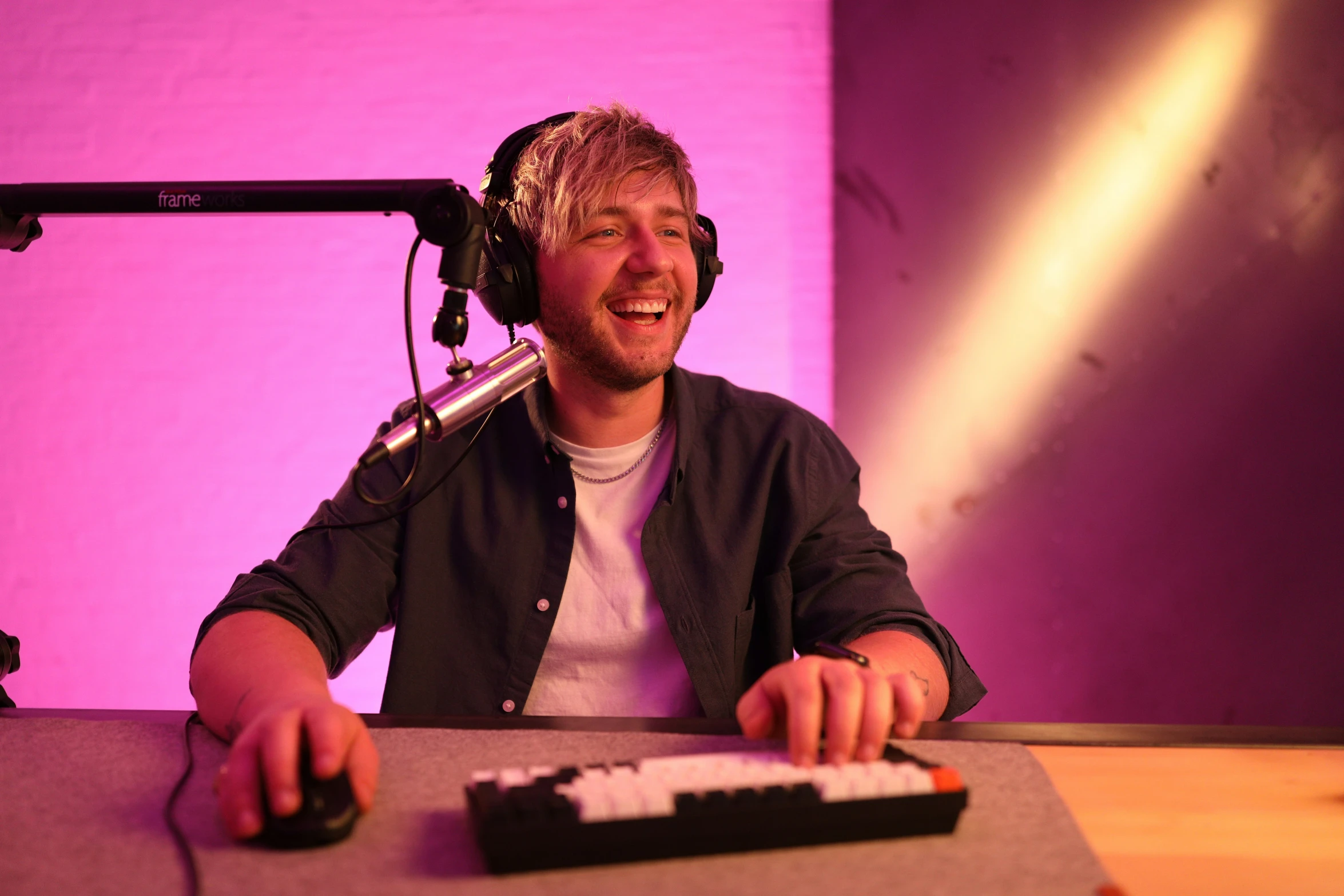 a guy with a microphone behind him in a recording studio