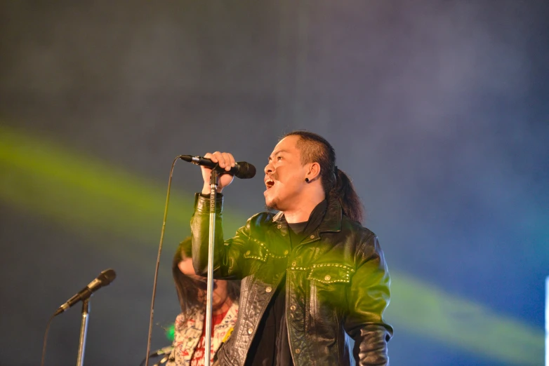 man standing at the microphone performing on stage