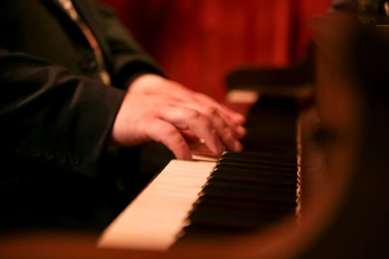 a man plays a piano inside a darkened room