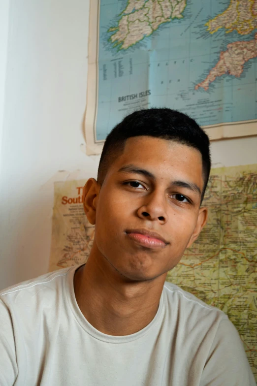 a young man looking to his left in front of maps