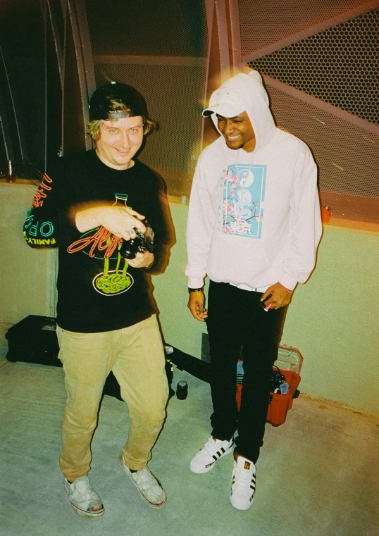 two young men in a sports outfit are standing