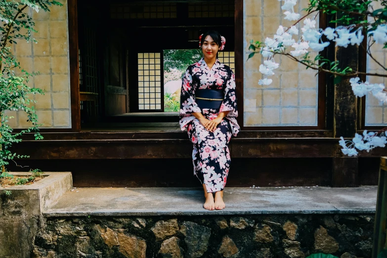 a woman standing by some flowers on the steps