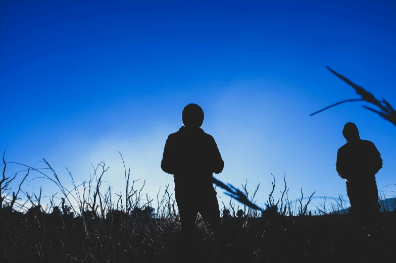 two people standing in the grass near each other