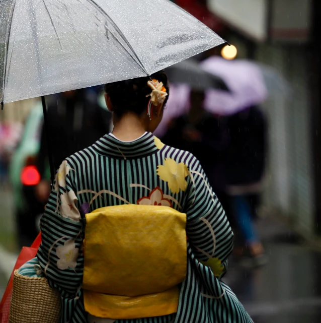 a woman carrying an umbrella while walking down the street