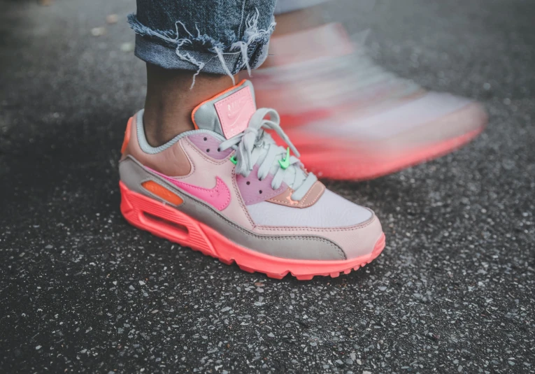 a person wearing neon pink sneakers on a street