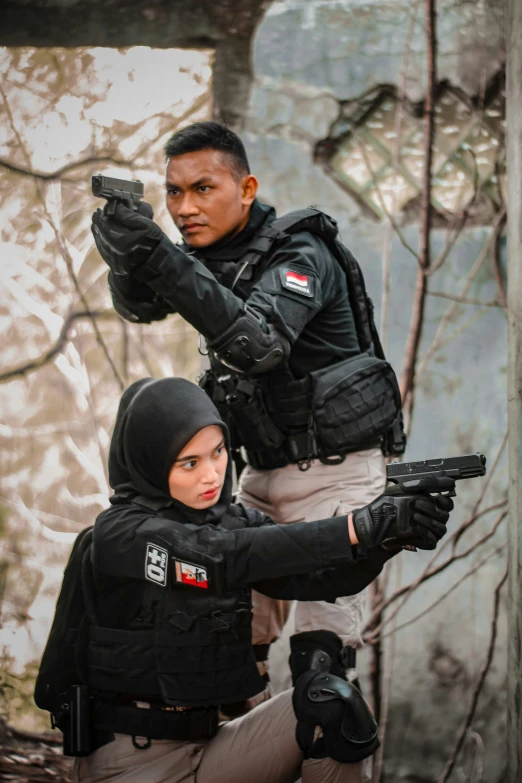 two people dressed in full gear and one holding a gun