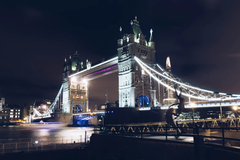 a view from the river of a bridge in a city at night