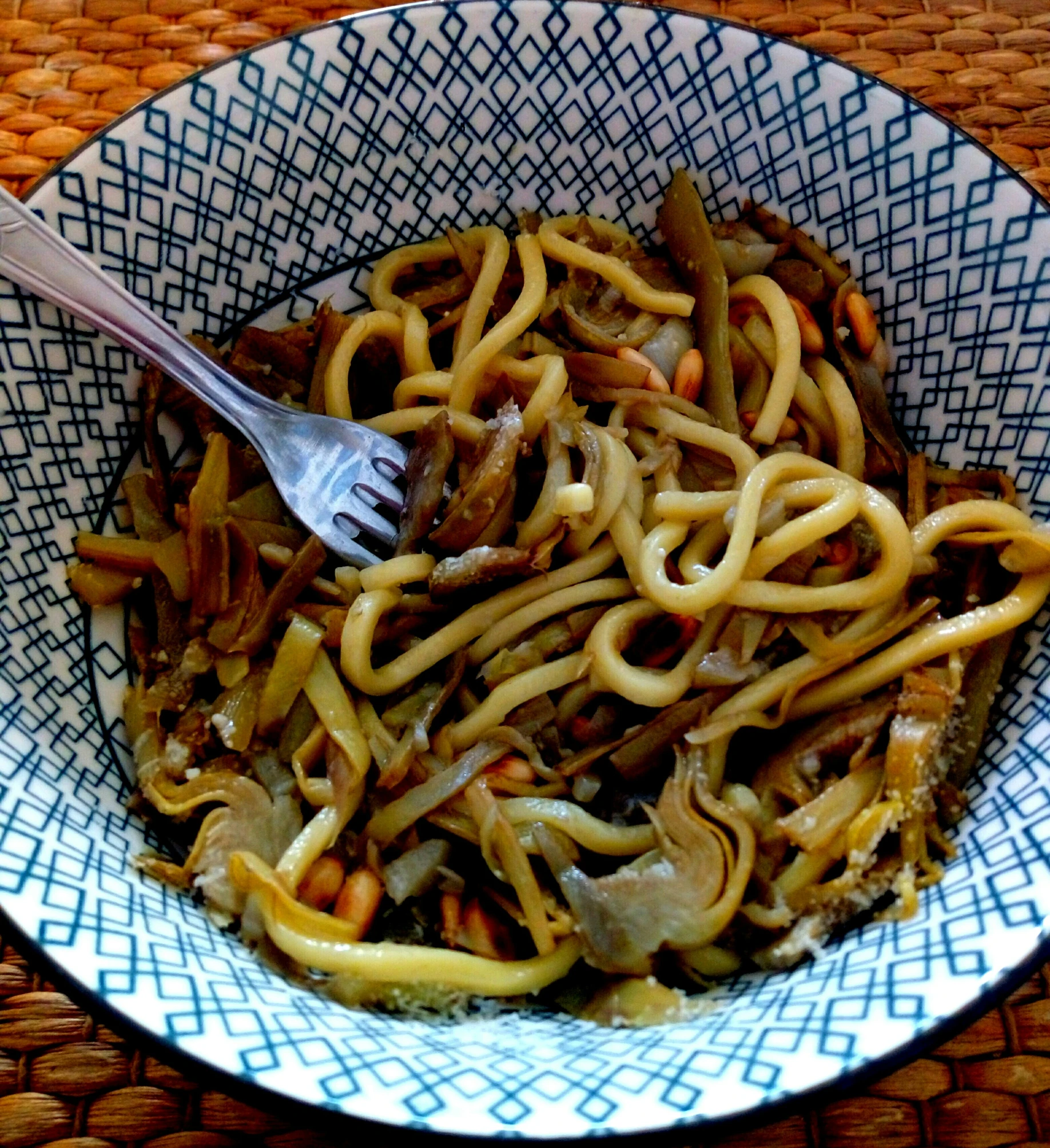 a bowl full of noodles, mushrooms, and sauce