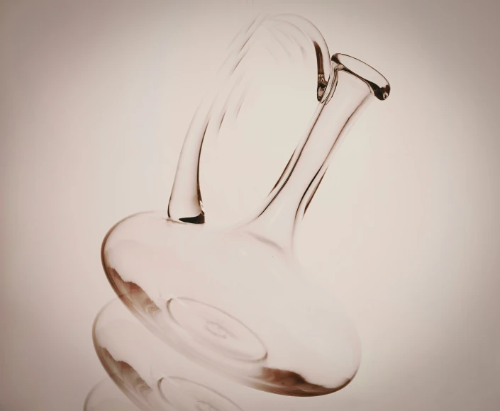 a clear glass vase sits on a white surface