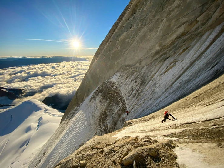 two climbers in a line climbing up a mountain