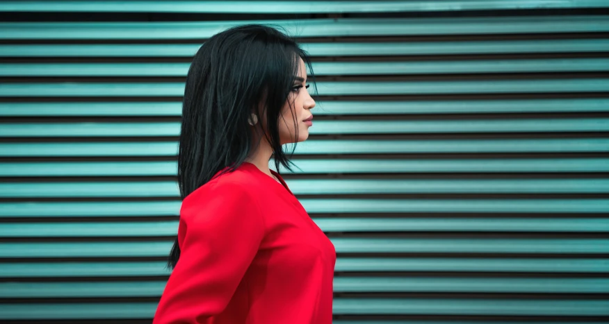 an asian woman with dark hair and blue eyes stares out