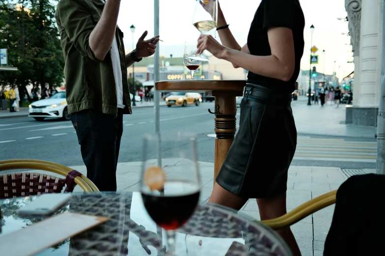 a woman drinking wine and two other people using the wineglasses