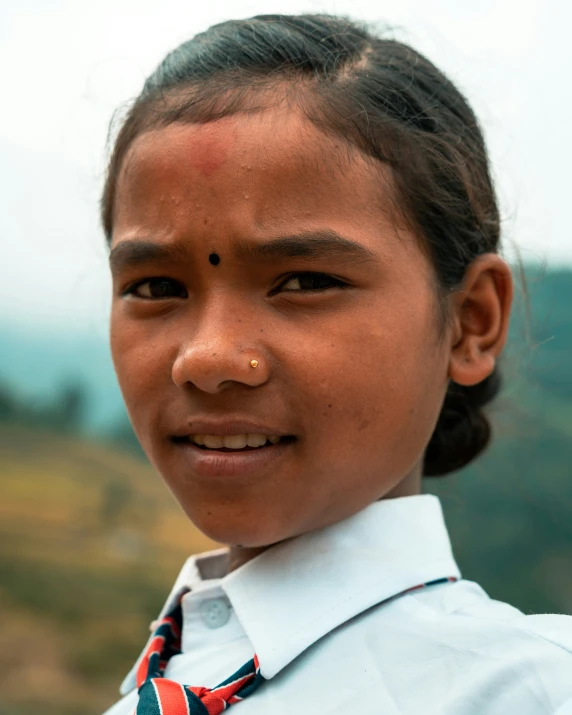 a young child in school uniform is smiling