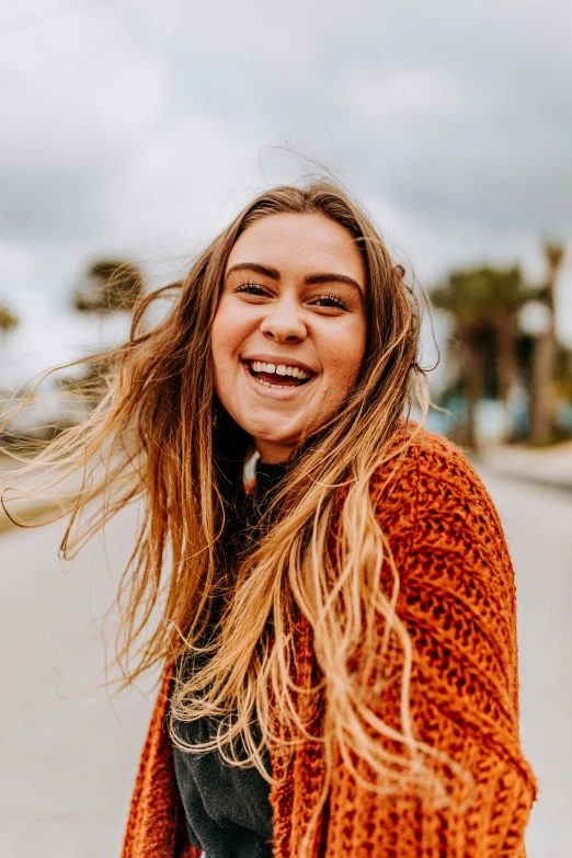 a smiling  with long blond hair and a scarf around her shoulders