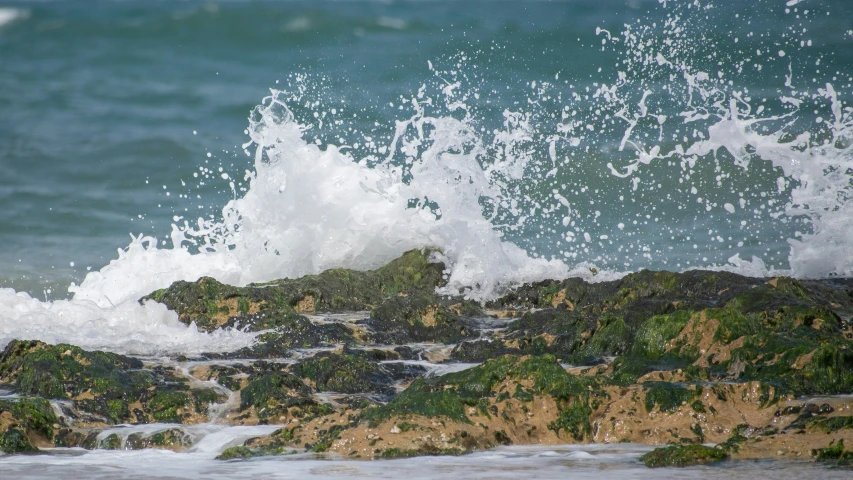 water splashes up against the edge of a rocky beach