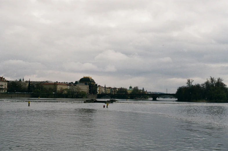 people in boats floating on water under gray skies