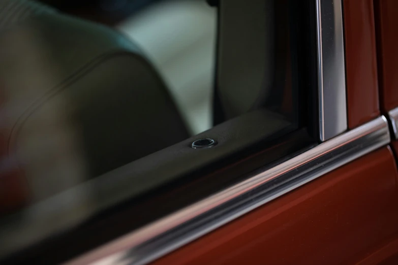 the window of a red car has a black glass