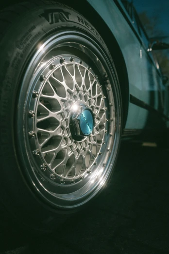 a car wheel that is painted silver and has a blue circle