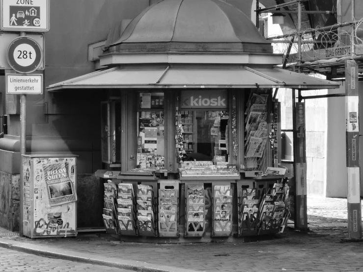 black and white po of grocery shop with sign for closing