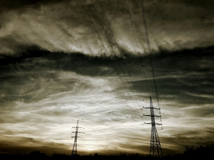 two radio towers against a stormy sky