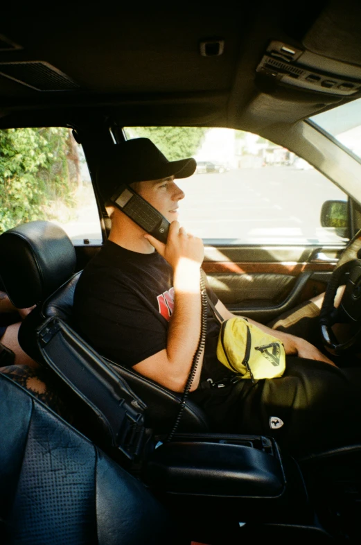 man with telephone and helmet sitting in his vehicle