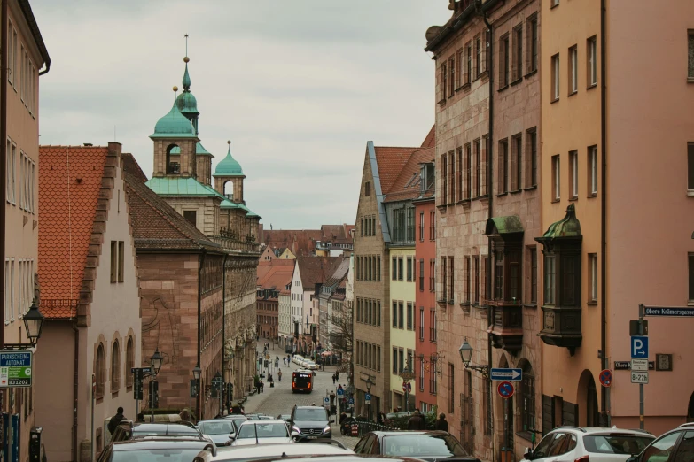 several cars and people driving down a narrow street