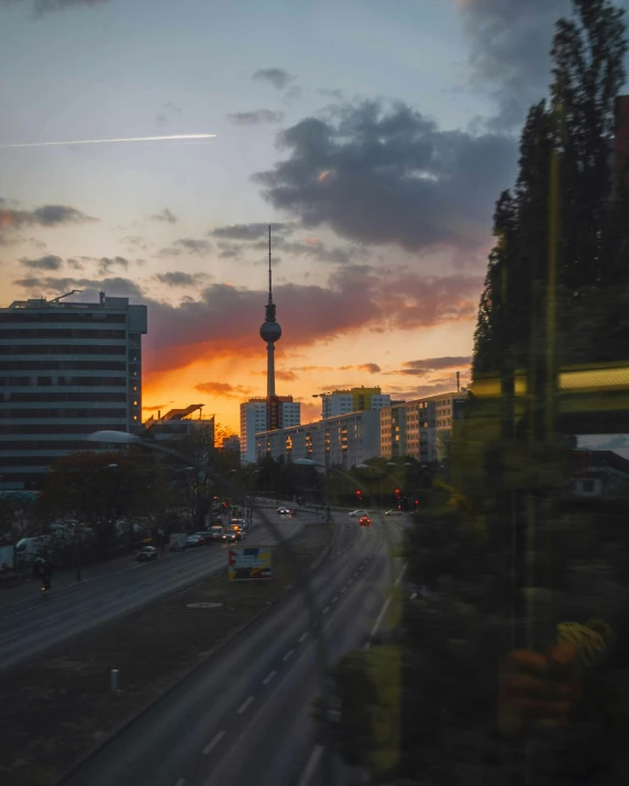 view of a large city at sunset with the television tower in the distance