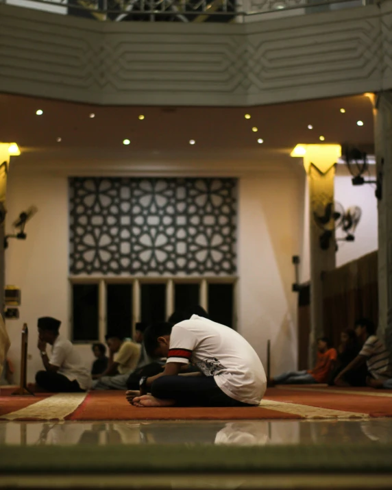 a man sitting on the ground while praying