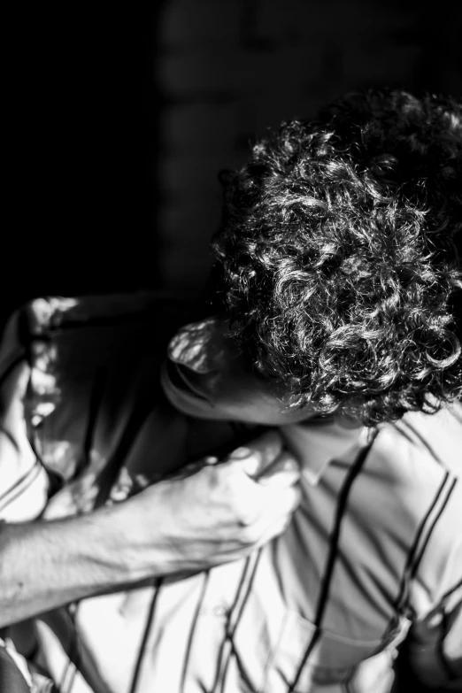 a man with curly hair has his face up to his head