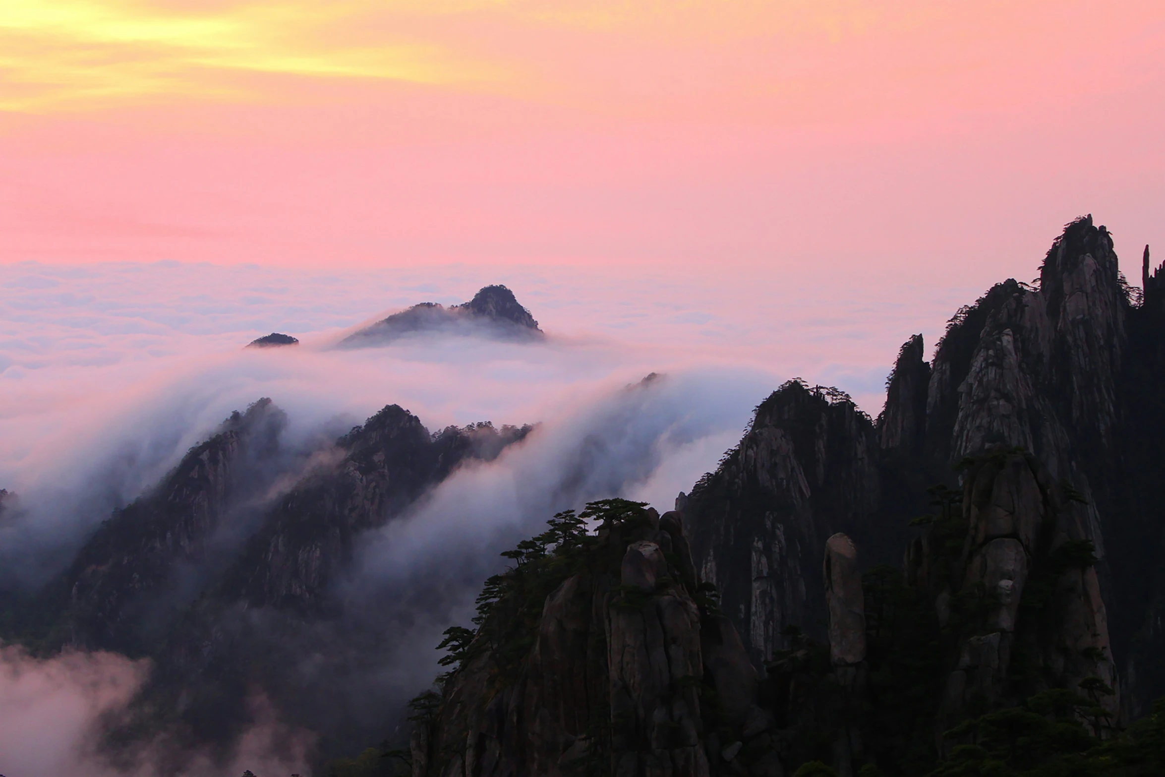 mountains shrouded by fog and clouds in the sunrise