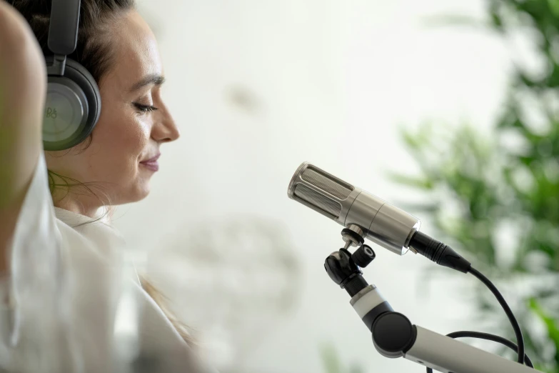 a woman with headphones looking at a microphone