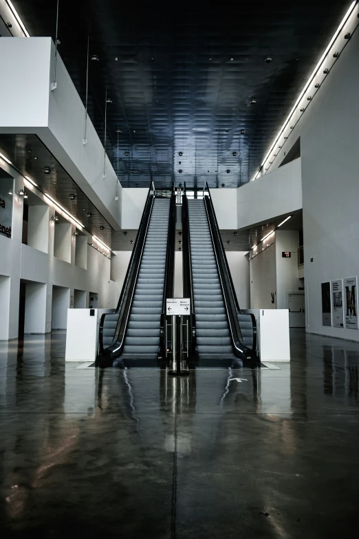 an escalator inside of a building next to two escalators