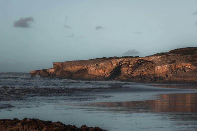 the shore is lined with large rocks and some little waves