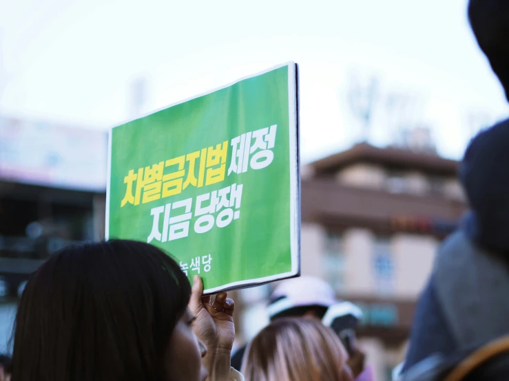 people standing outside holding up signs in a protest