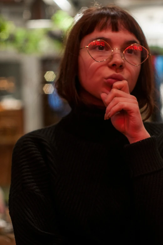 a woman wearing glasses in front of a table