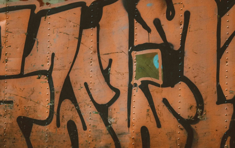 a yellow and green box sitting next to a rusted metal wall