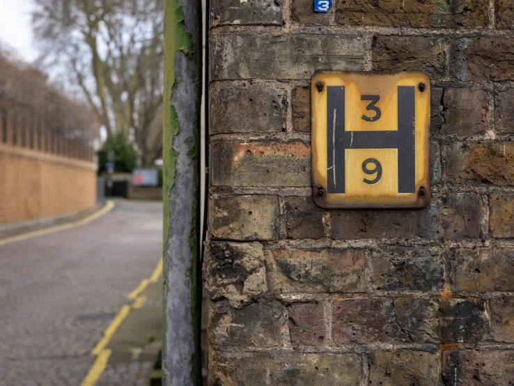 a sign posted on the side of a brick wall